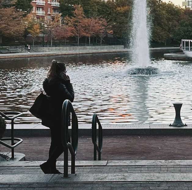 Woman on phone at Lechmere Canal Park Cambridge MA Cambridge MA womens hair solutions